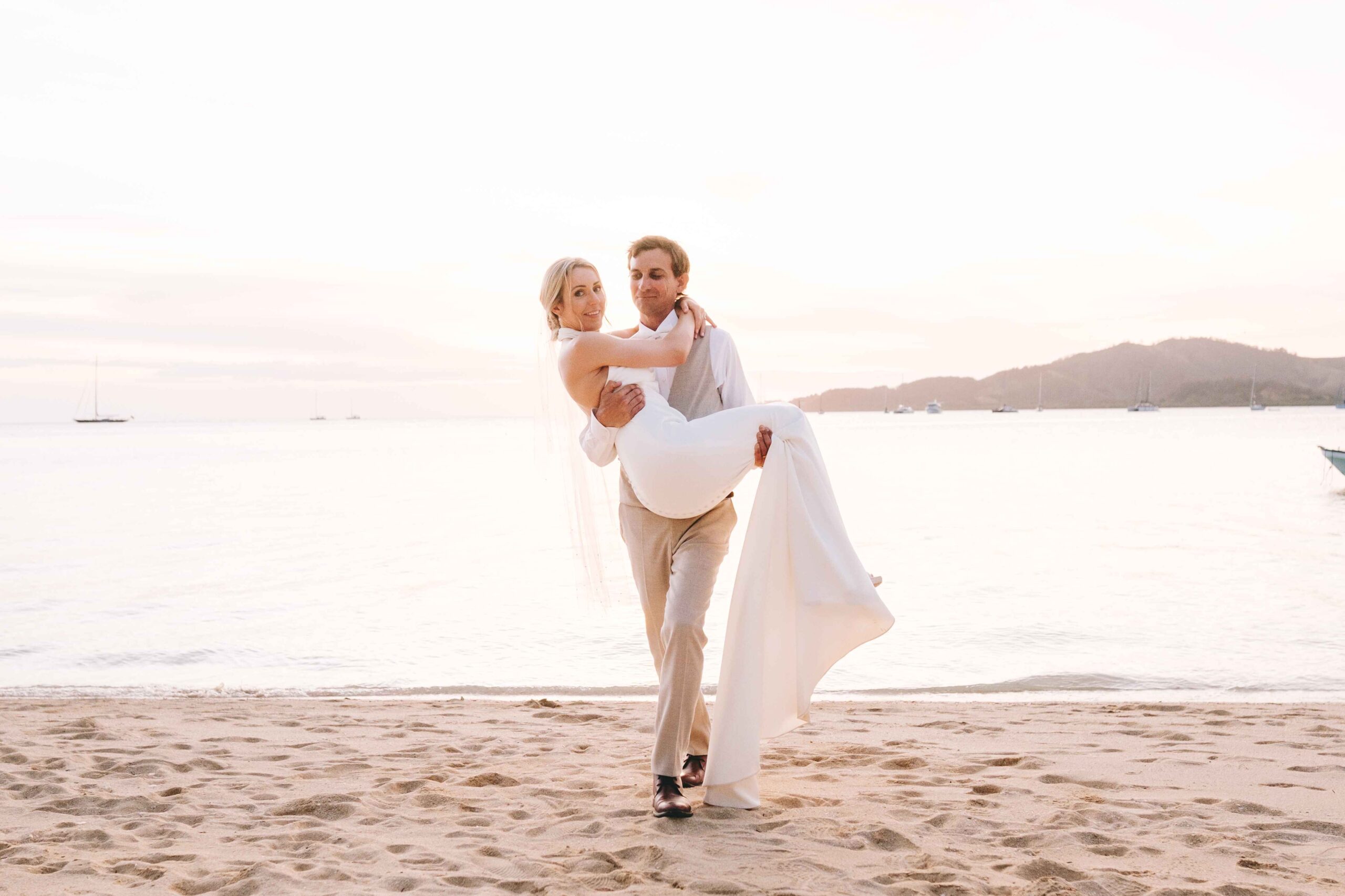 Real Wedding - Plantation Island Resort - Kelly + Ian - groom carrying the bride by the beach